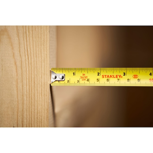 STANLEY 0-30-696 tape measure photography, close-up on yellow blade measuring wood.