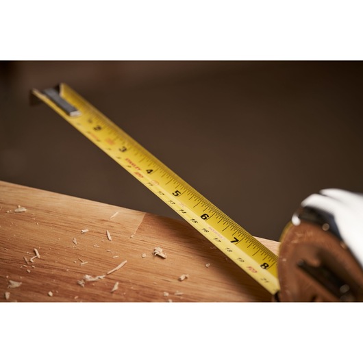 STANLEY 0-33-531 tape measure extended across wood with shavings, close-up angle.