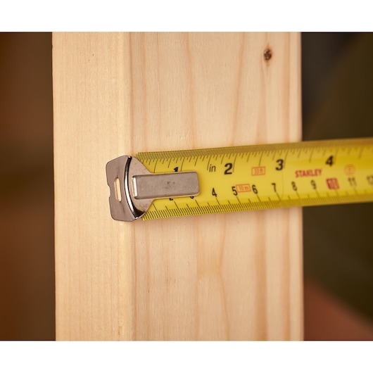 STANLEY 0-33-531 tape measure extended on light wood, close-up side angle.
