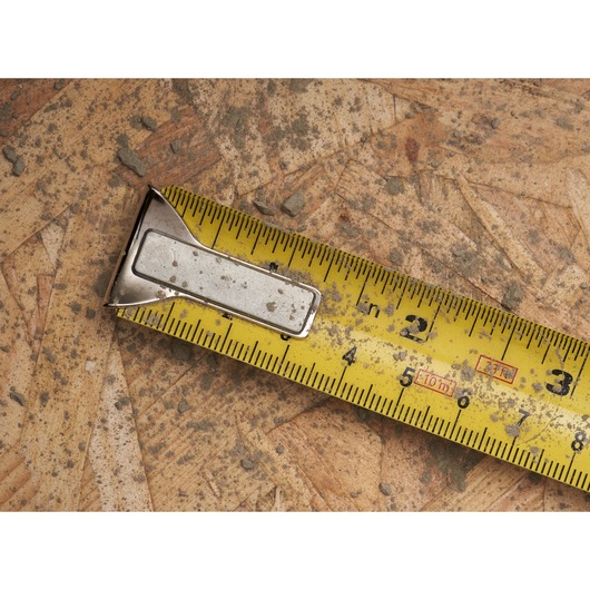 STANLEY 0-33-531 tape measure, yellow blade with black markings, close-up angled on wooden surface.