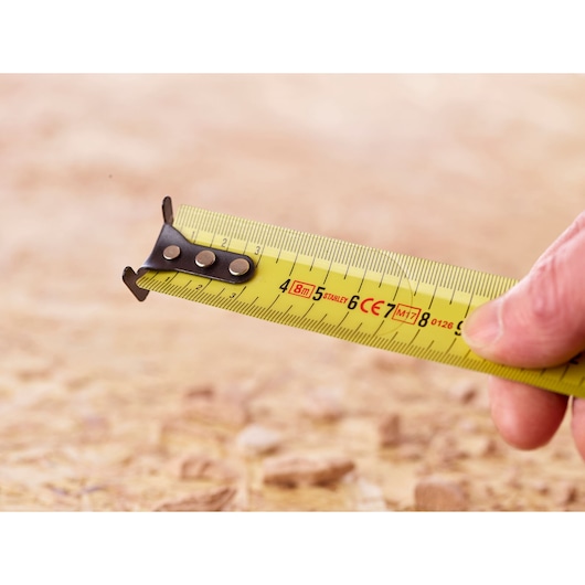 STANLEY 0-33-728 yellow tape measure close-up, showing metric markings and hook tip.