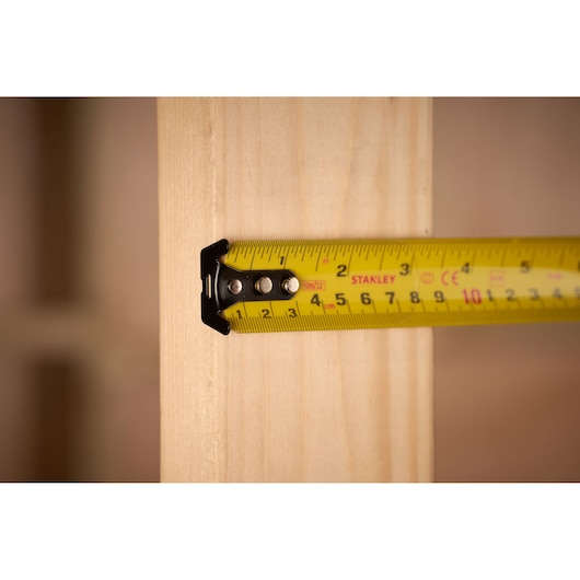 STANLEY 0-33-805 tape measure measuring wood, close-up product photo.
