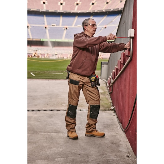 STANLEY 0-65-443 screwdriver used by a worker adjusting an outdoor electrical box near a stadium field.