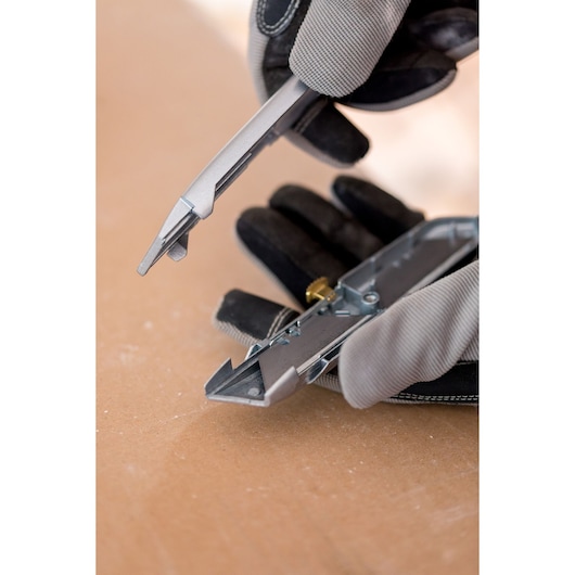 STANLEY 1-10-099 utility knife in close-up, showing blade change detail with gloved hands.