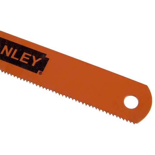 Close-up of an orange Stanley saw blade with sharp teeth and a hole at the end.