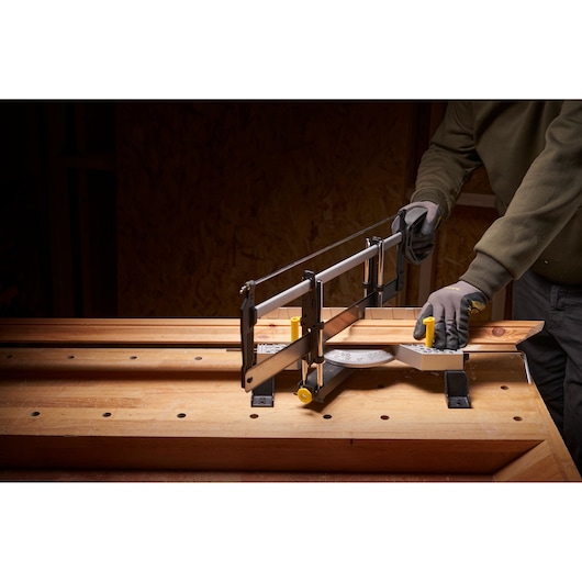 STANLEY 1-20-800 hand mitre saw in use on wooden workbench, cutting angled wood piece.