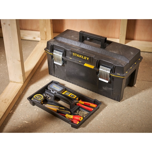 STANLEY 1-94-749 toolbox with tray of hand tools and screws on workshop floor.