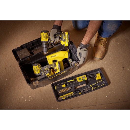 STANLEY 1-94-858 tool box with yellow power tools and hand tools, photo from above on workshop floor.