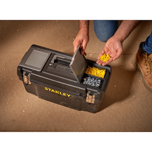 STANLEY 1-94-858 tool box with open lid, showing yellow wall plugs and metal fasteners, top angle.