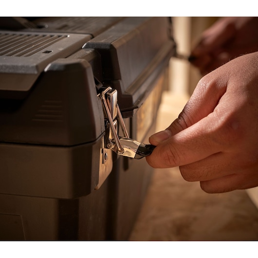 STANLEY 1-94-858 toolbox close-up with hand unlocking metal latch.