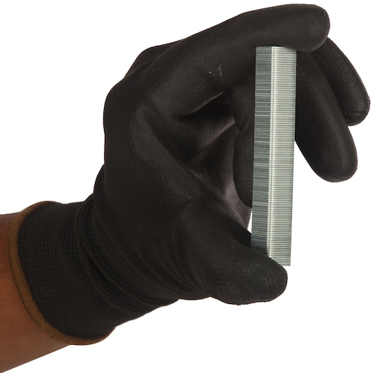 STANLEY 1-TRA206T staples stack held by gloved hand, product side view, photography.