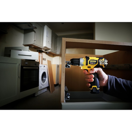 STANLEY FMC010LB cordless drill used to assemble kitchen cabinet, photography of product in action.