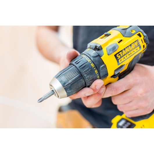 STANLEY FMC607B cordless drill driver in yellow and black, close-up in hand.