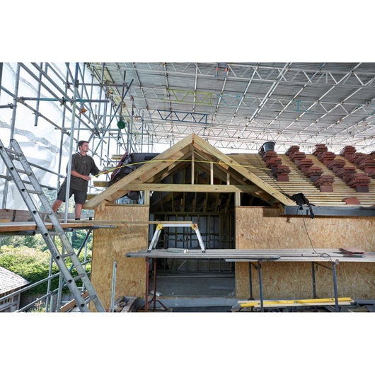 STANLEY FMHT0-36336 photography of a house construction site with scaffolding and roof work visible.
