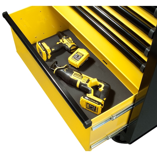 Yellow tool drawer with Stanley power tools and batteries neatly placed inside.