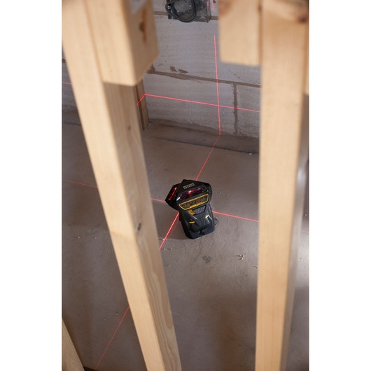 STANLEY FMHT1-77357 laser level projecting red lines in a construction site, shown from above.