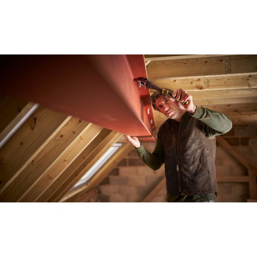 STANLEY FMHT13126-0 adjustable wrench in use tightening bolt on steel beam in attic construction.