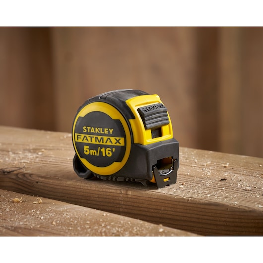 STANLEY FMHT33006-5 FATMAX 5m/16' tape measure on wooden planks, close-up photography.
