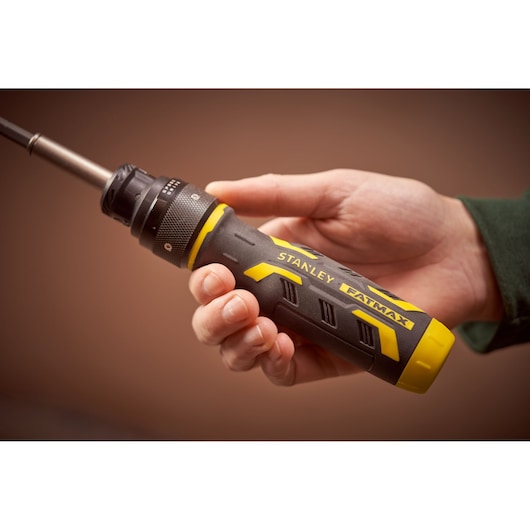 STANLEY FMHT62692-0 FATMAX ratcheting screwdriver held in hand, black and yellow handle, side view.