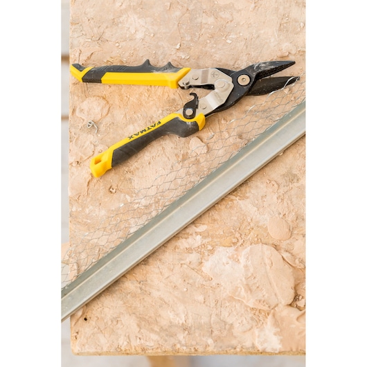 STANLEY FMHT73756-0 aviation snip with yellow and black handle on a workbench, shown from above.