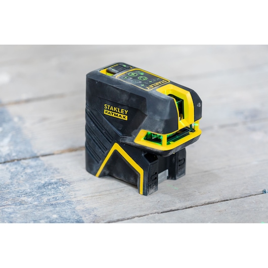 STANLEY FMHT77598-1 laser level, black and yellow, photography of tool on wooden surface.