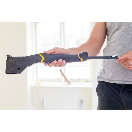 Photo of STANLEY FMHT81394-9 drywall carrier tool being held by a person indoors.