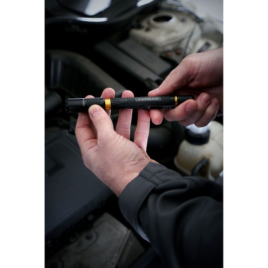 Stanley FMHT81510-0 FATMAX black pen light held by hands near car engine, product in use.