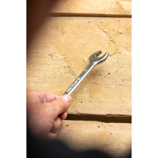 Photo of STANLEY FMMT13033-0 open-end wrench held by hand on a wooden surface.