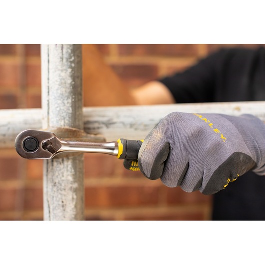 STANLEY FMMT82678-0 ratchet being used on metal pipe, worker wearing grey gloves.