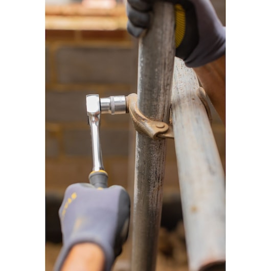 Photo of STANLEY FMMT82685-1 ratchet used to tighten a scaffold clamp on a metal pipe.