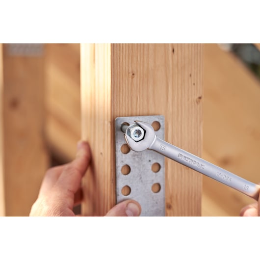 Photo of STANLEY FATMAX FMMT82848-0 ratcheting wrench tightening a bolt on a metal bracket attached to wood.