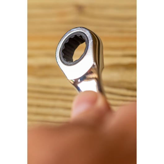 STANLEY FMMT82849-0 ratcheting wrench close-up in hand, silver finish, tool on wood background.