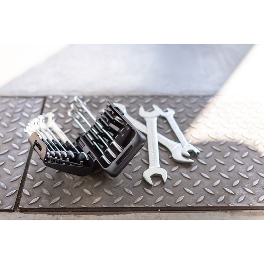 STANLEY FMMT82901-0 wrench set in black case with loose wrenches on textured metal floor, angled view.