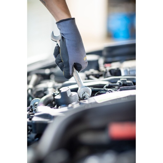 Photo of a gloved hand using a STANLEY FMMT82901-0 wrench to tighten a bolt in a car engine bay.