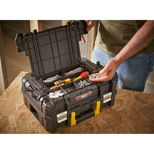 STANLEY FMST1-71967 toolbox with open lid, showing compartments with tools and hardware, on a workbench.