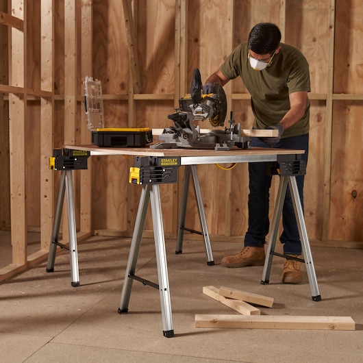 STANLEY FMST1-75763 photography, metal sawhorse work table used for woodworking in a construction setting.