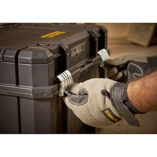 STANLEY FMST1-75796 toolbox close-up, gloved hands locking metal latches, product photography.