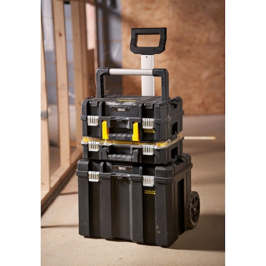 Stanley FMST1-80103 stackable rolling tool boxes with telescopic handle, shown in a workshop setting.