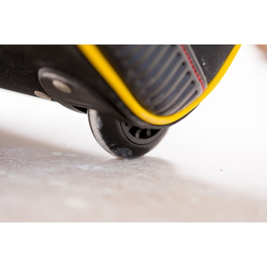 STANLEY FMST82706-1 photography close-up of black and yellow bag wheel touching floor.