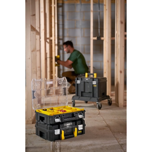 STANLEY FMST82967-9 stackable tool organizer with yellow compartments open on construction site floor.