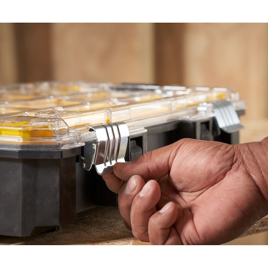 Photo of STANLEY FMST82967-9 organizer box, hand opening metal latch, close-up angle.
