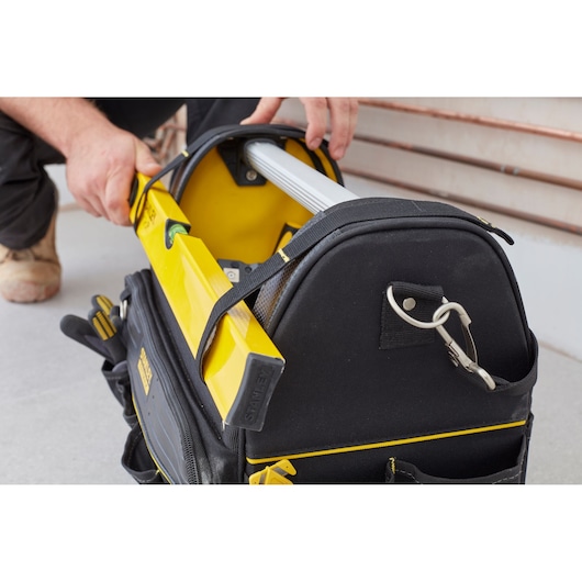 Photo of STANLEY FMST83296-1 tool bag in use, black with yellow trim, holding tools and a yellow level.