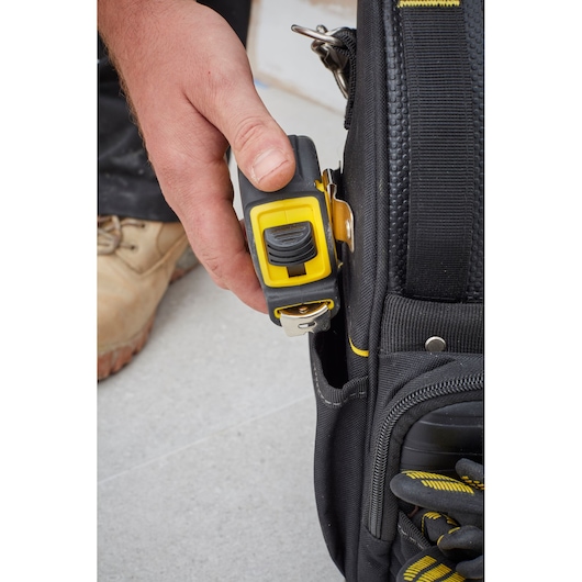 STANLEY FMST83296-1 tool bag close-up with yellow tape measure clipped to pocket.