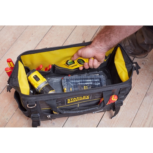 STANLEY FMST83297-1 tool bag with yellow interior, filled with tools and accessories, top-down angle.
