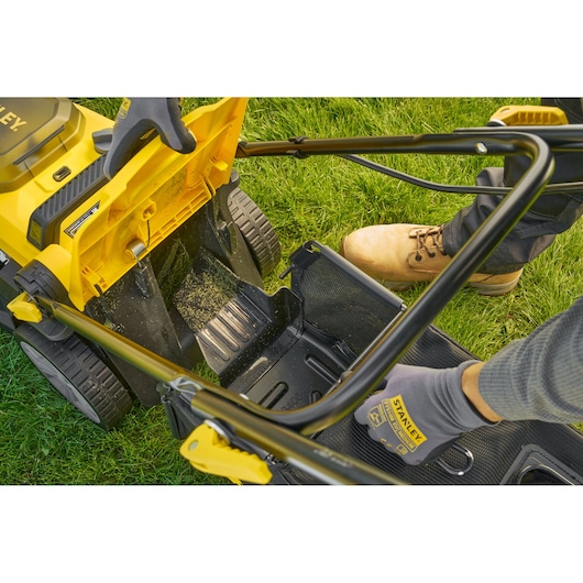 STANLEY SCMWP3401M1-XE lawn mower photo, close-up of grass catcher attachment on green lawn.