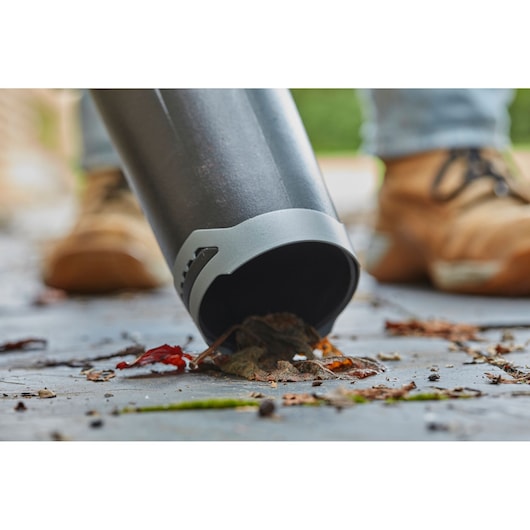 STANLEY SFMCBL7M1 blower nozzle close-up clearing leaves on pavement.