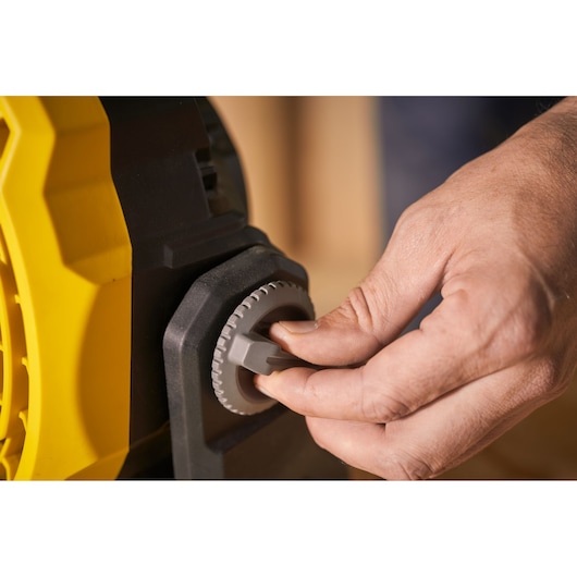 Close-up photo of a hand adjusting the dial on a STANLEY SFMCE001B power tool.