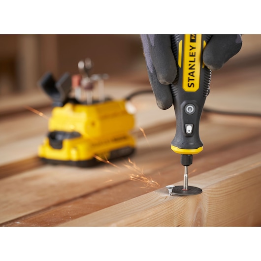 STANLEY SFMCE030B rotary tool used on wood, with sparks flying, close-up photography angle.
