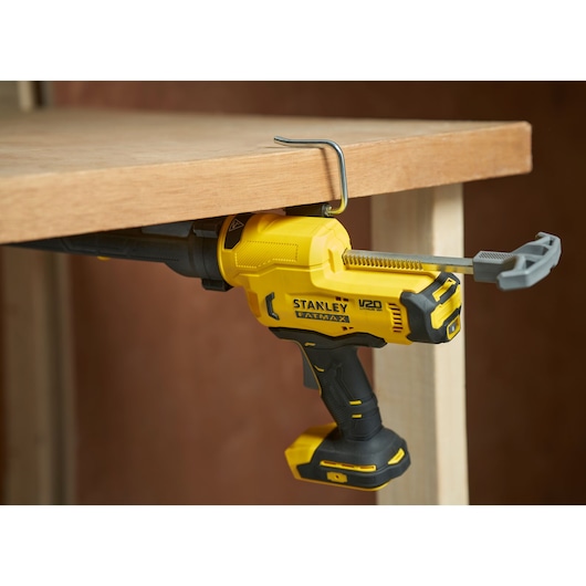 STANLEY SFMCE600B cordless reciprocating saw clamped to a wooden table, side view.