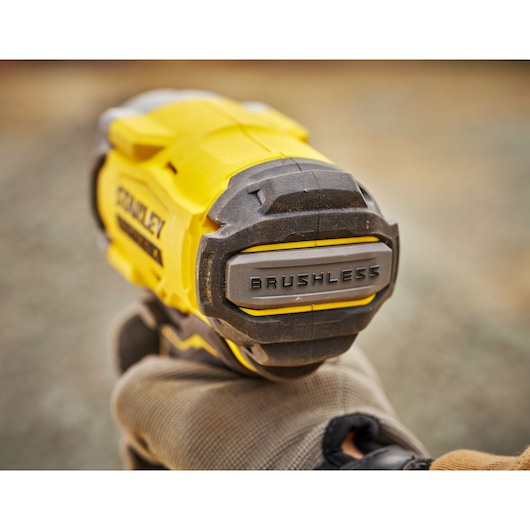 Stanley SFMCF920B brushless impact driver close-up in use, yellow and black housing, photography.